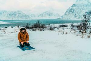 A Muslim traveling through arctic cold regions while performing the Muslim prayer namaz during breaks photo