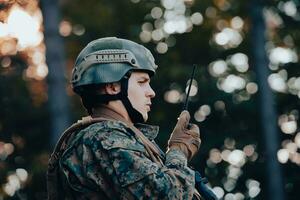 moderno guerra soldado comandante oficial hablando portátil radio estación y dar pedidos subdivisión equipo foto