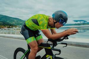Full length portrait of an active triathlete in sportswear and with a protective helmet riding a bicycle. Selective focus photo