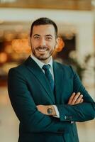 Portrait of a businessman in a suit with his arms crossed in a modern office building photo