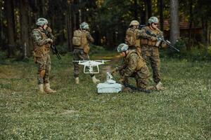 Modern Warfare Soldiers Squad are Using Drone for Scouting and Surveillance During Military Operation in the Forest. photo