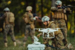 Modern Warfare Soldiers Squad are Using Drone for Scouting and Surveillance During Military Operation in the Forest. photo