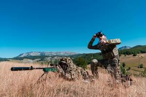francotirador soldado asistido por un asistente a observar el zona a ser dirigido con moderno guerra táctico virtual realidad gafas de protección aéreo zumbido militar tecnología. foto