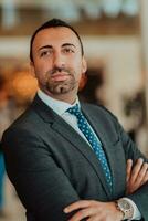 Portrait of a businessman in a suit with his arms crossed in a modern office building photo