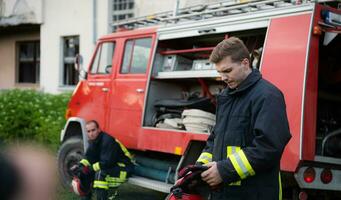 Firefighter with uniform and helmet stand in front of electric wire on a roof top photo