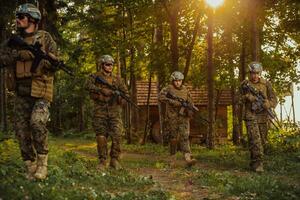 A group of modern warfare soldiers is fighting a war in dangerous remote forest areas. A group of soldiers is fighting on the enemy line with modern weapons. The concept of warfare and military conflicts photo