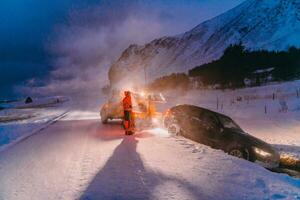 The roadside assistance service pulling the car out of the canal. An incident on a frozen Scandinavian road. photo