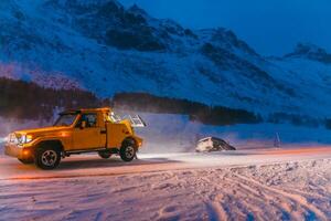 The roadside assistance service pulling the car out of the canal. An incident on a frozen Scandinavian road. photo