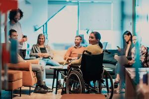 mujer de negocios en silla de ruedas teniendo negocio reunión con equipo a moderno oficina. un grupo de joven autónomos de acuerdo en nuevo en línea negocio proyectos foto