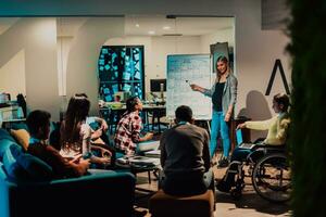 A pregnant businesswoman leads a creative meeting of a diverse business team in a modern coworking photo