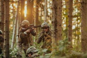 A group of modern warfare soldiers is fighting a war in dangerous remote forest areas. A group of soldiers is fighting on the enemy line with modern weapons. The concept of warfare and military conflicts photo