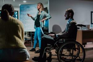 un embarazada mujer de negocios Guías un creativo reunión de un diverso negocio equipo en un moderno trabajo colaborativo foto