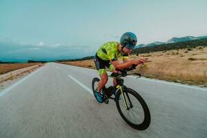 Full length portrait of an active triathlete in sportswear and with a protective helmet riding a bicycle. Selective focus photo