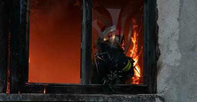 bombero héroe que lleva bebé niña fuera desde ardiente edificio zona desde fuego incidente. rescate personas desde peligroso sitio foto