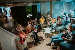 An older Muslim businesswoman presents a project to a young diverse team of people in a modern office photo