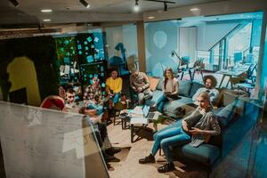 An older Muslim businesswoman presents a project to a young diverse team of people in a modern office photo