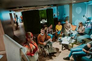 An older Muslim businesswoman presents a project to a young diverse team of people in a modern office photo