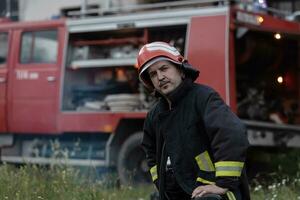 Deprimido y cansado bombero cerca fuego camión. foto