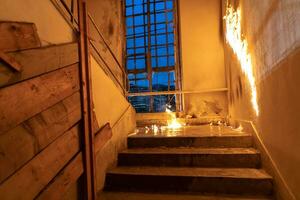 valiente bombero desciende escalera de un ardiente edificio y sostiene salvado niña en su brazos. abierto fuego y uno bombero en el antecedentes. foto