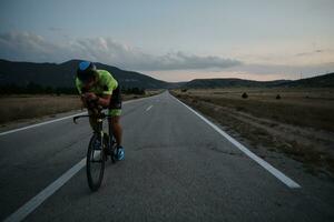 atleta de triatlón montando bicicleta por la noche foto