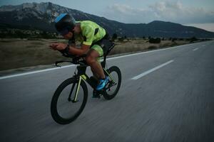 atleta de triatlón montando bicicleta por la noche foto