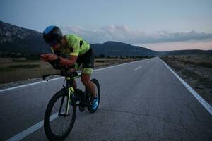 atleta de triatlón montando bicicleta por la noche foto
