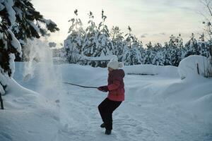 girl throwing fresh snow at beautiful sunny winter day photo