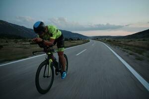 triathlon athlete riding bike at night photo