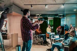 A bearded man in a modern office explaining to his young diverse team how a drone working photo