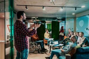 A bearded man in a modern office explaining to his young diverse team how a drone working photo