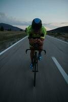 triathlon athlete riding bike at night photo