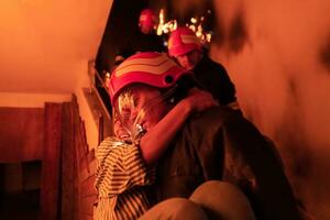 Brave Fireman Descends Stairs of a Burning Building and Holds Saved Girl in His Arms. Open fire and one Firefighter in the Background. photo