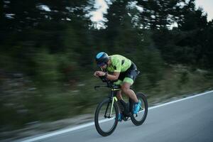 atleta de triatlón montando bicicleta por la noche foto