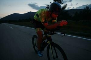 triathlon athlete riding bike at night photo