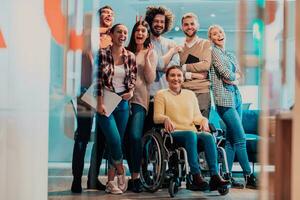 Businesswoman in a wheelchair on break in a modern office with her team in the background photo