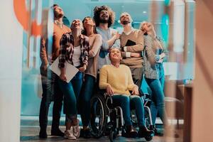 Businesswoman in a wheelchair on break in a modern office with her team in the background photo