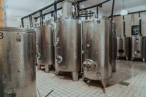 Modern wine distillery and brewery with brew kettles pipes and stainless steel tanks photo