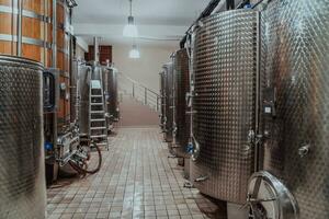 Modern wine distillery and brewery with brew kettles pipes and stainless steel tanks photo