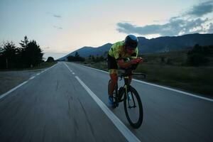 atleta de triatlón montando bicicleta por la noche foto