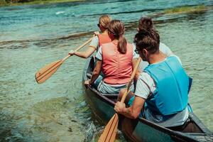 Group adventurous explorer friends are canoeing in a wild river photo