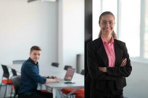 Portrait of young smiling business woman in creative open space coworking startup office. Successful businesswoman standing in office with copyspace. Coworkers working in background. photo