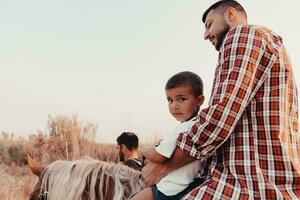 Father and son enjoy riding horses together by the sea. Selective focus photo