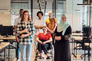 un diverso grupo de joven negocio personas congrega dentro un moderno Inauguración acristalado oficina, presentando inclusividad con un persona en un silla de ruedas, un africano americano joven hombre , y un vestido con hijab mujer, exhibiendo un dinámica mezcla de innovación y foto