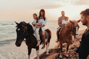 la familia pasa tiempo con sus hijos mientras montan a caballo juntos en una playa de arena. enfoque selectivo foto