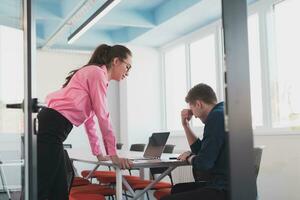 Emotional couple of young colleagues arguing in modern office. Business woman shouting at her sad man assistant, copy space, side view photo