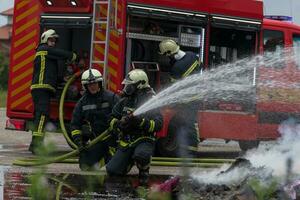 Firefighters fight the fire flame to control fire not to spreading out. Firefighter industrial and public safety concept. Traffic or car accident rescue and help action. photo