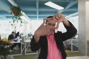 Closeup of hands, Smiling Business Woman Making Frame Gesture with at modern bright coworking open space startup office. photo