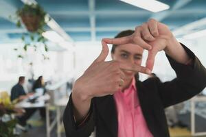 Closeup of hands, Smiling Business Woman Making Frame Gesture with at modern bright coworking open space startup office. photo