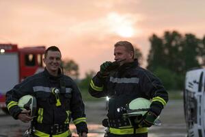 fireman using walkie talkie at rescue action fire truck and fireman's team in background. photo