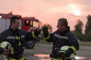 Fireman using walkie talkie at car traffic rescue action fire truck and fireman's team in background. photo